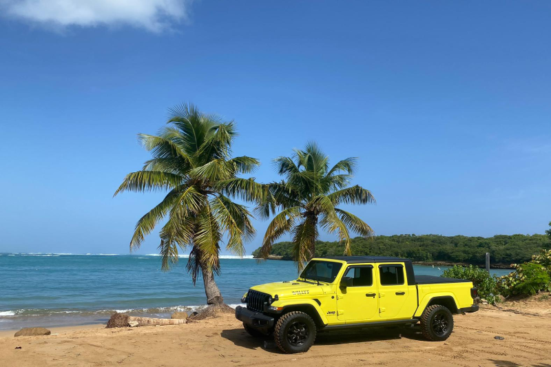 Yellow Jeep rental parked on a beach along the Puerto Rico coastline